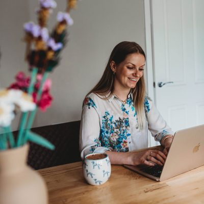 Conversion copywriter - Tasmin at Fika Digital is smiling while typing on her Macbook